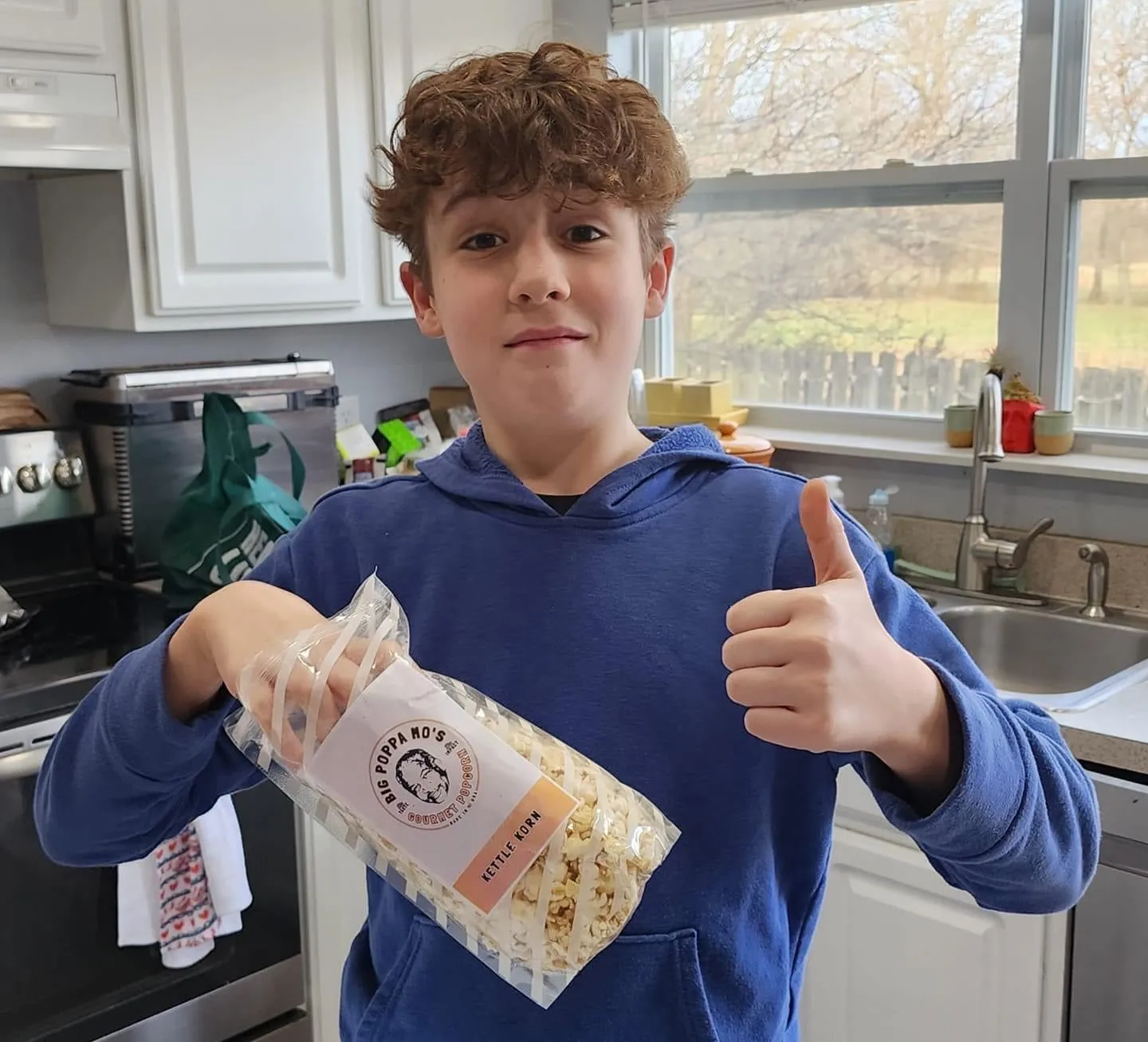 Customer photo showing a thumbs-up while holding a bag of Kettle Korn popcorn.